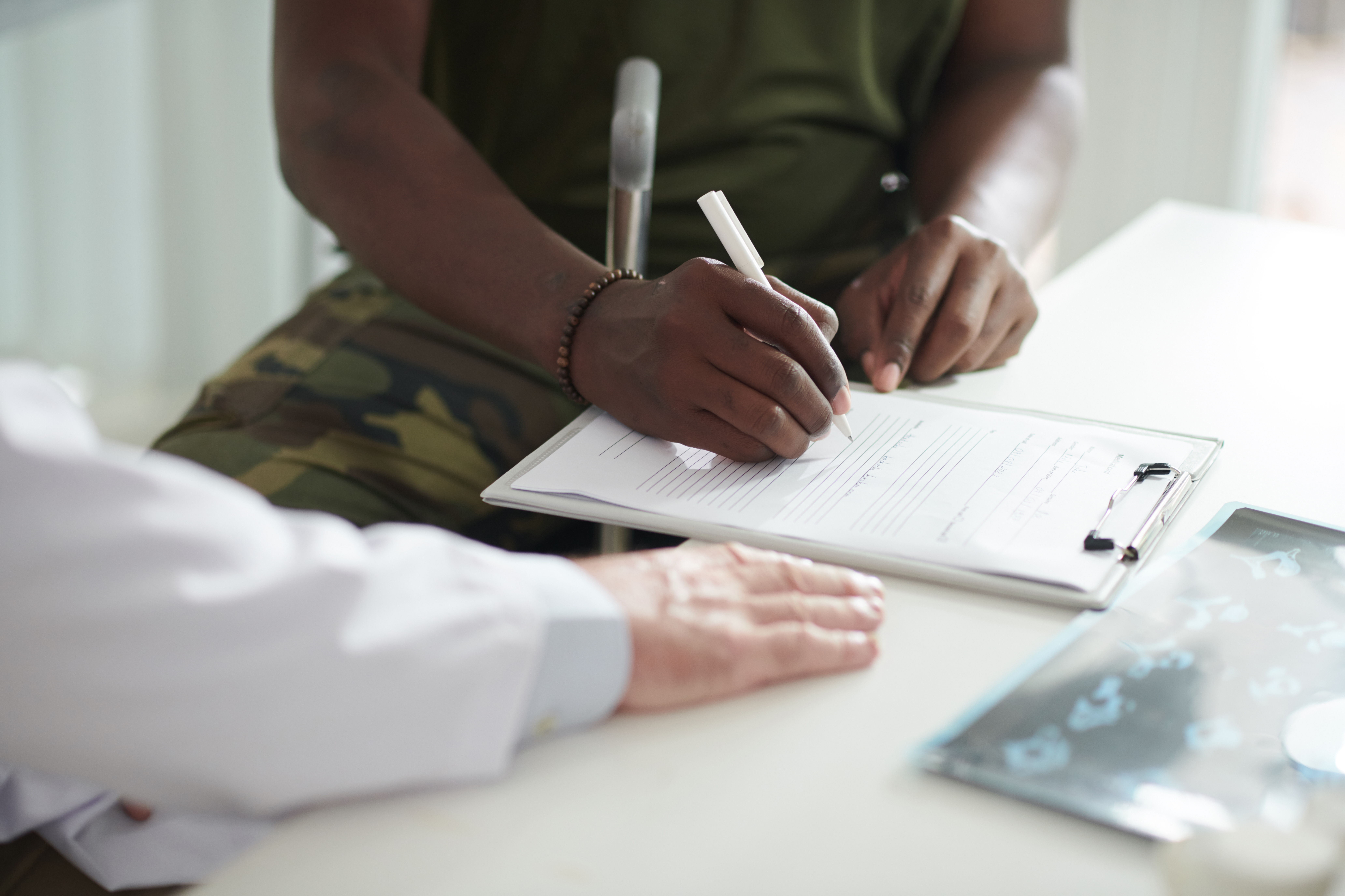 Versicherungsberatung für Soldaten Soldat unterschreibt Unterlagen bei einer Versicherungsberatung
